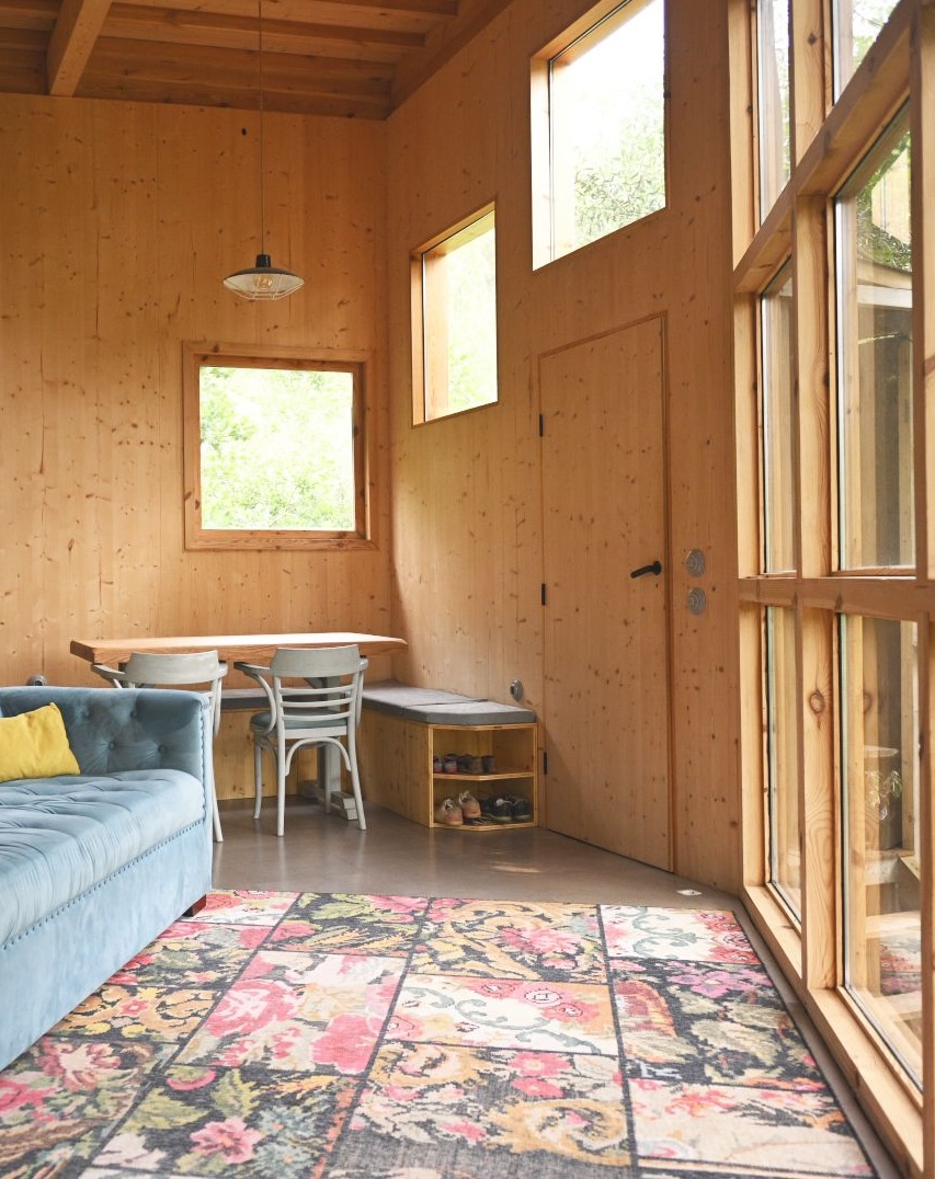 Double-height interior with tall glass looking onto greenery