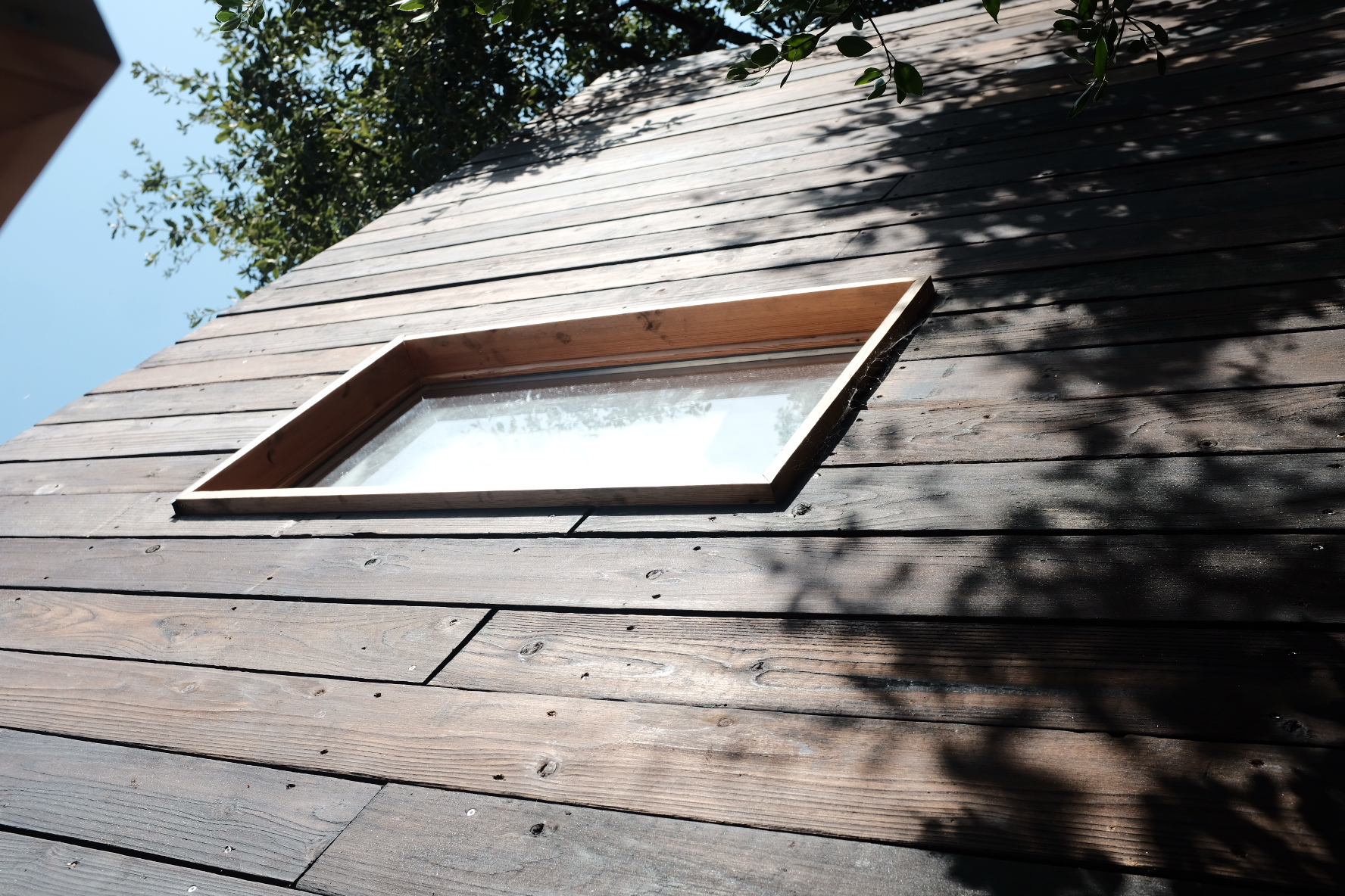 Charred yakisugi cladding with a window catching the sun